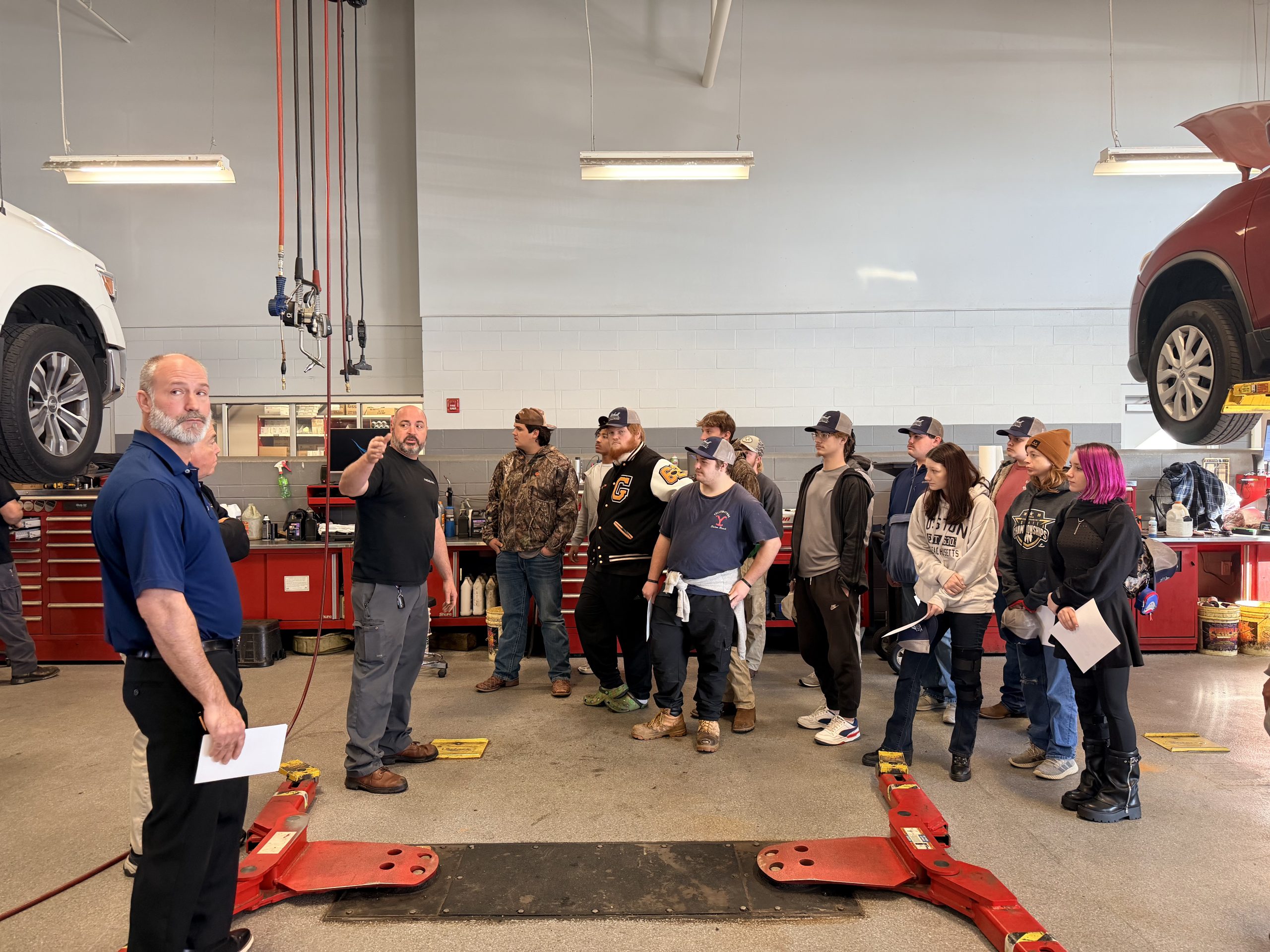 Students observing technicians working in the Mitchell Nissan service bays