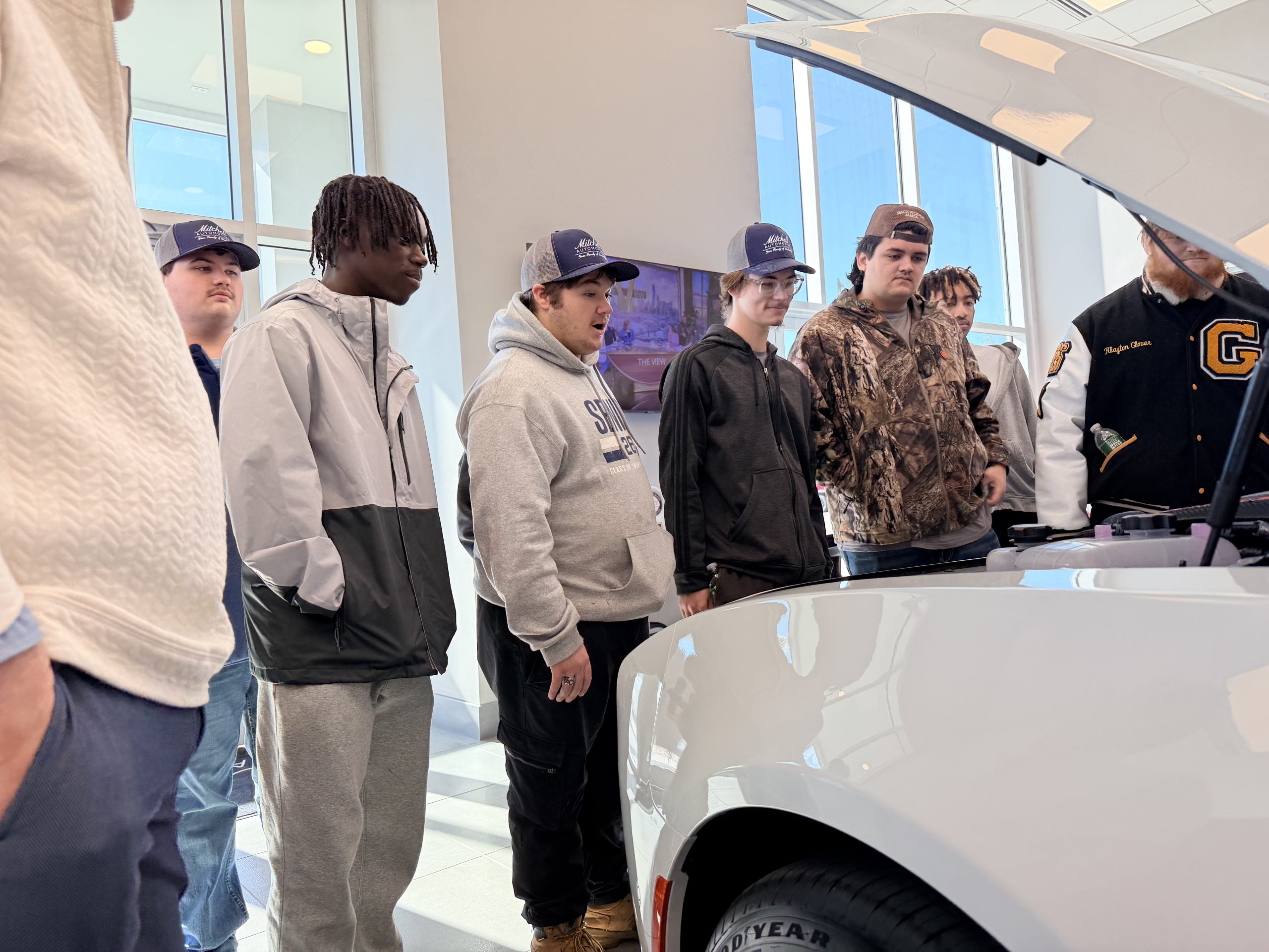 Students viewing the 2026 Dodge Charger Scat Pack during dealership tour